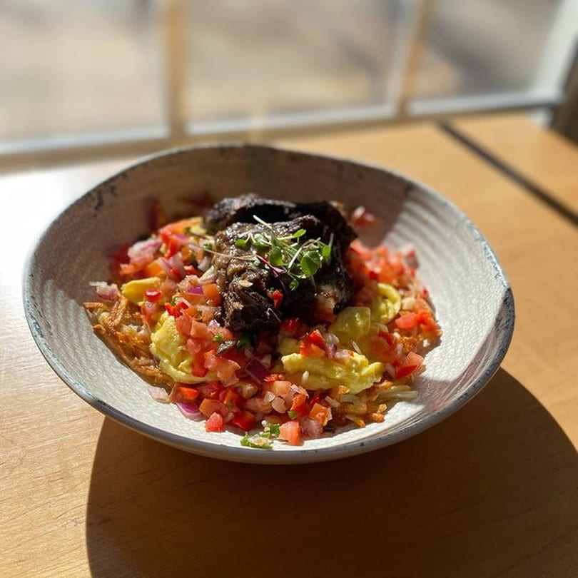 Good Kitchen's healthy breakfast bowl with hash browns, scrambled eggs, pico de gallo, and braised short rib.